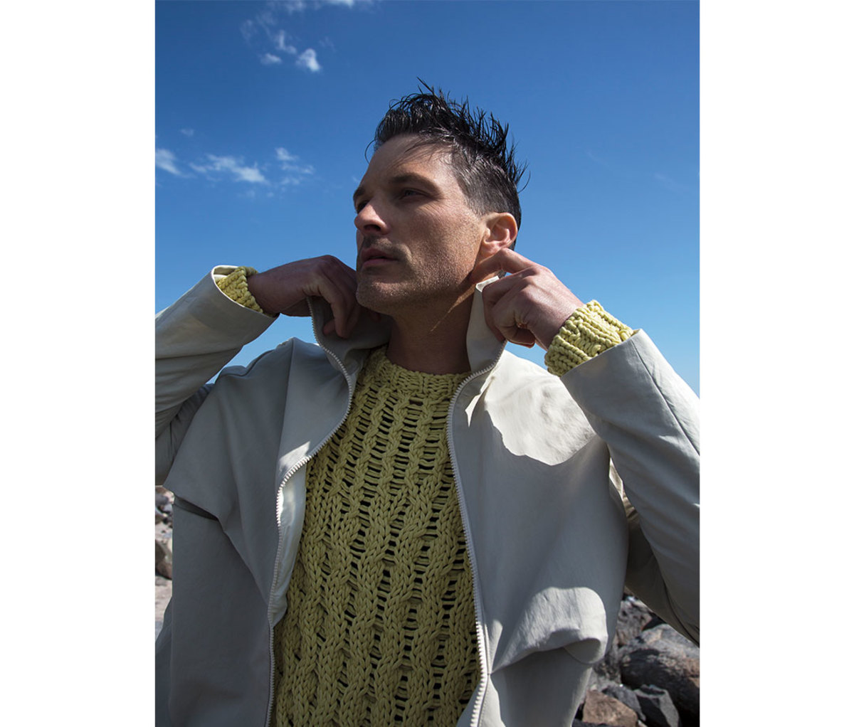 Man wearing yellow cable knit sweater under jacket