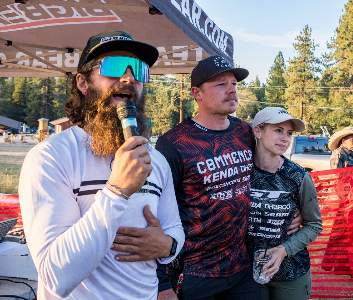 An announcer standing next to Kyle and Rachel Strait, the event's organizers.