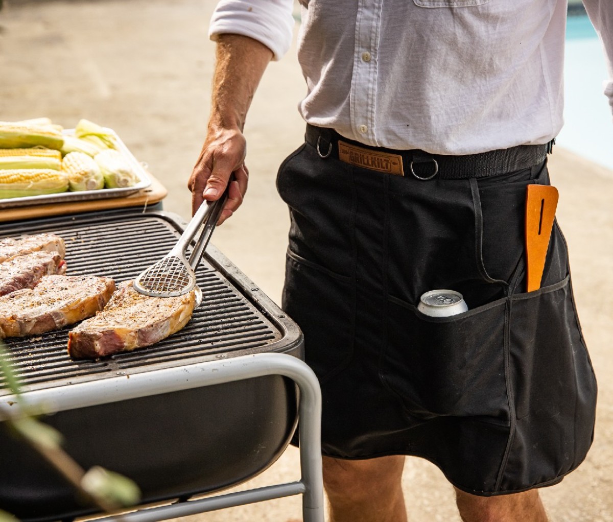 A man grilling while wearing a grillkilt.