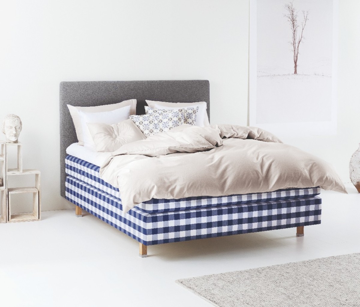 A image of a blue plaid Hästens Herlewing mattress in a bedroom.