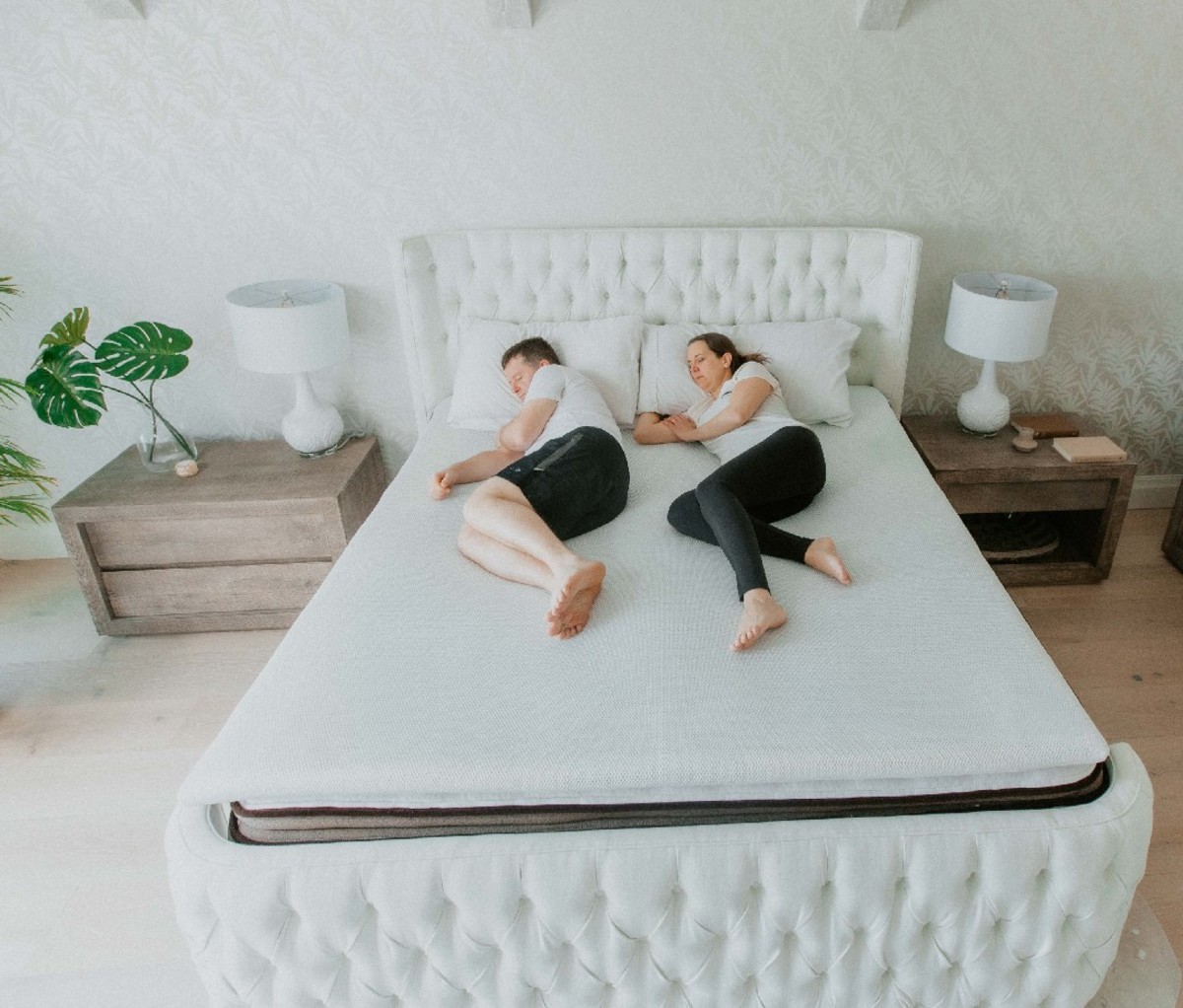 A couple lying down on a The Smart Topper by Perfectly Snug topper.