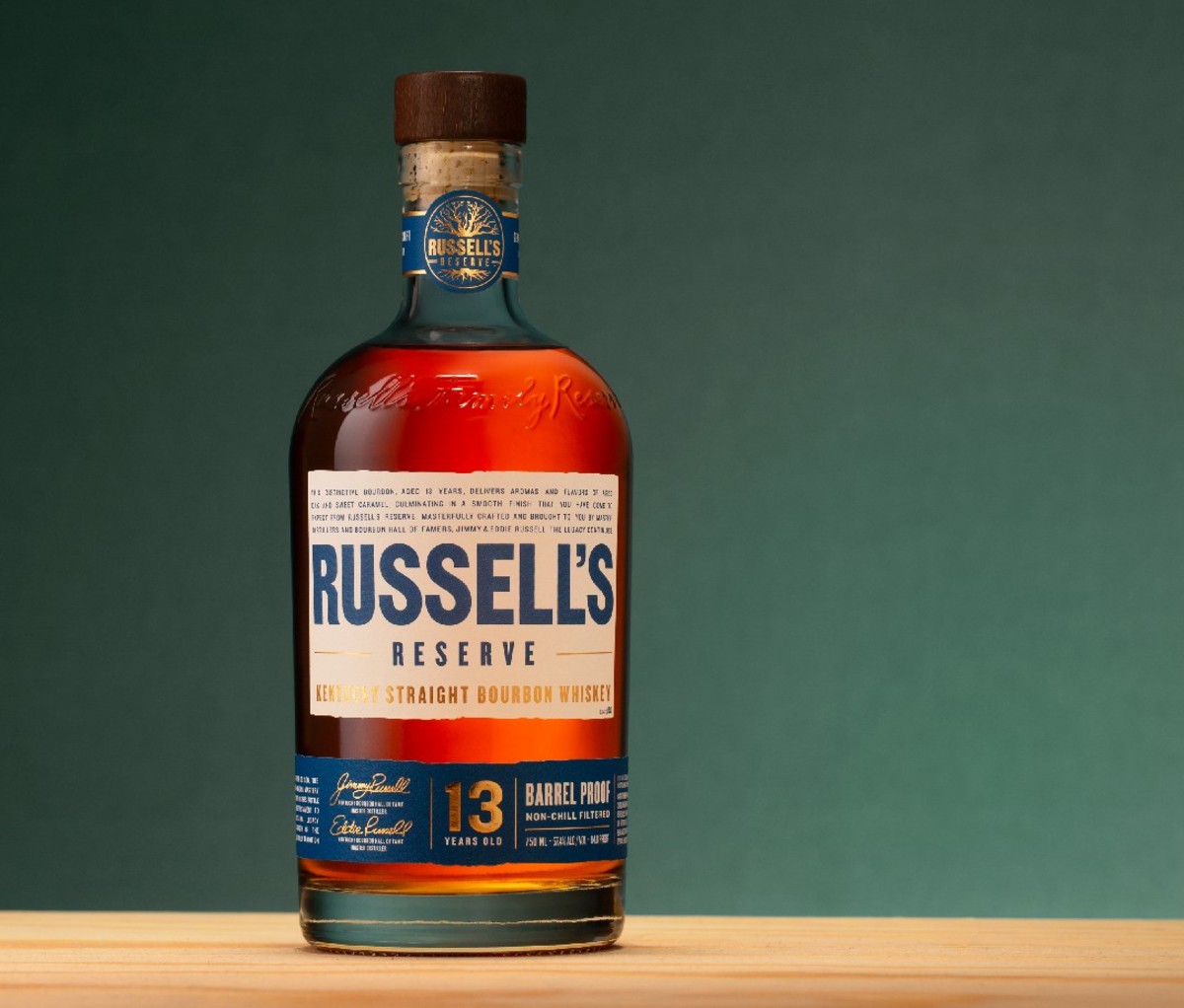 Bottle of Russell’s Reserve 13-Year-Old bourbon against green backdrop