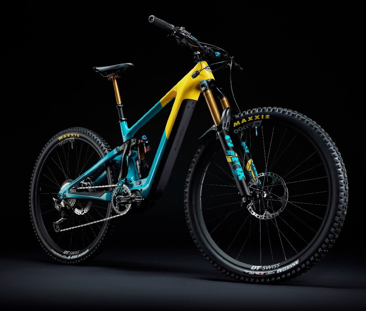 Bright blue and yellow electric mountain bike against black backdrop