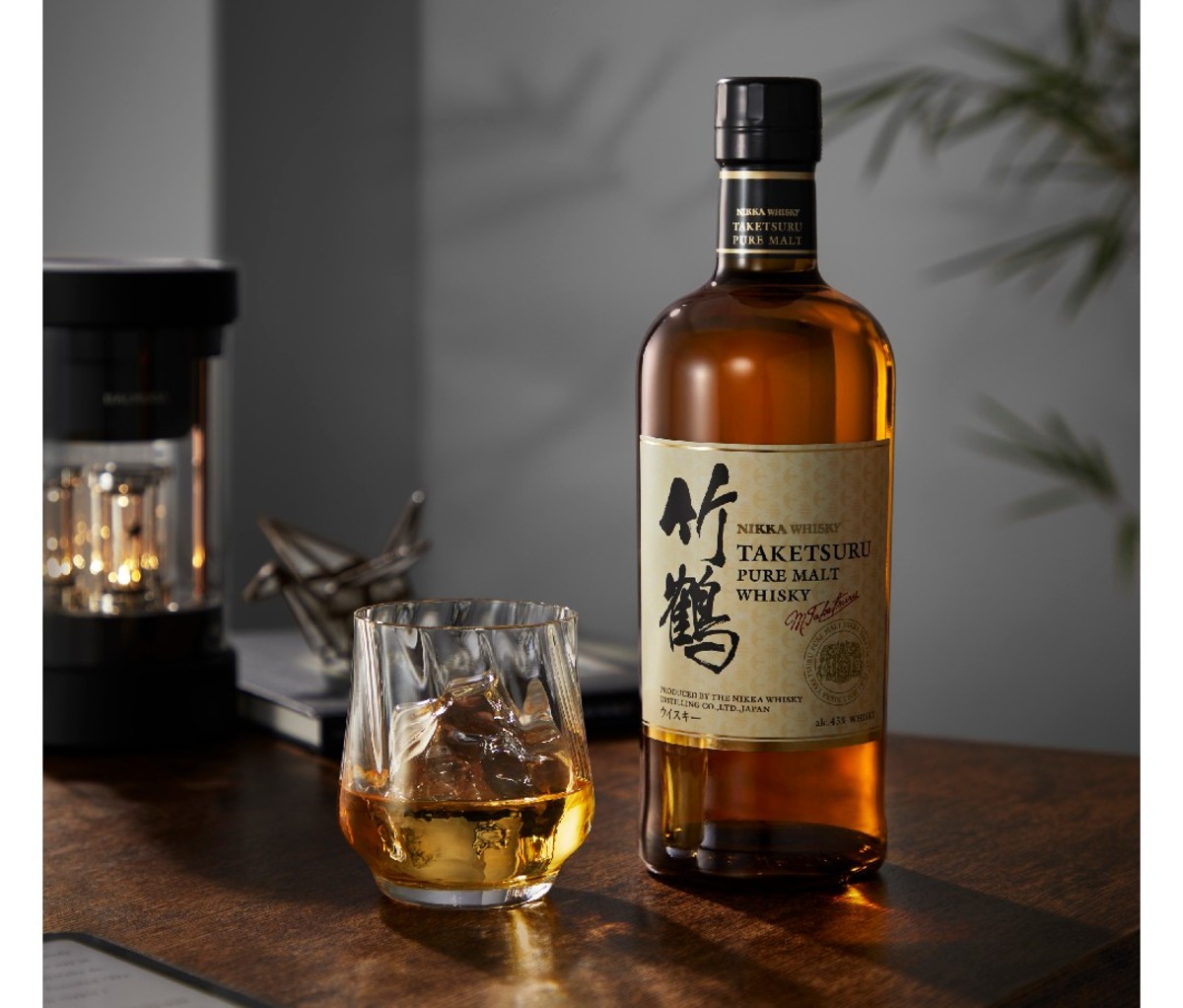 Bottle of Nikka-Taketsuru whisky on a bar with a glass of whisky beside it
