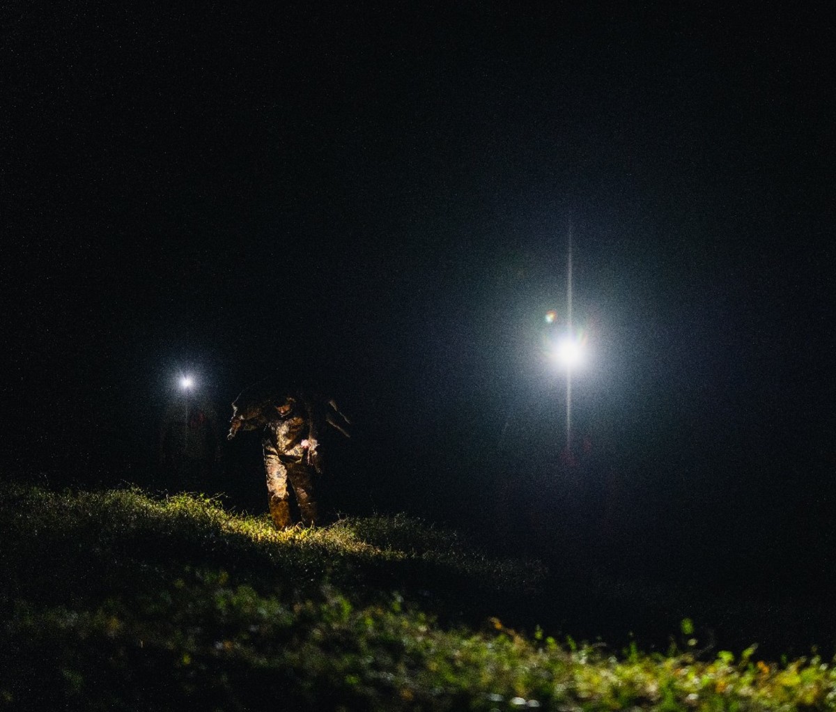 Working in the field at nighttime with bright spotlights