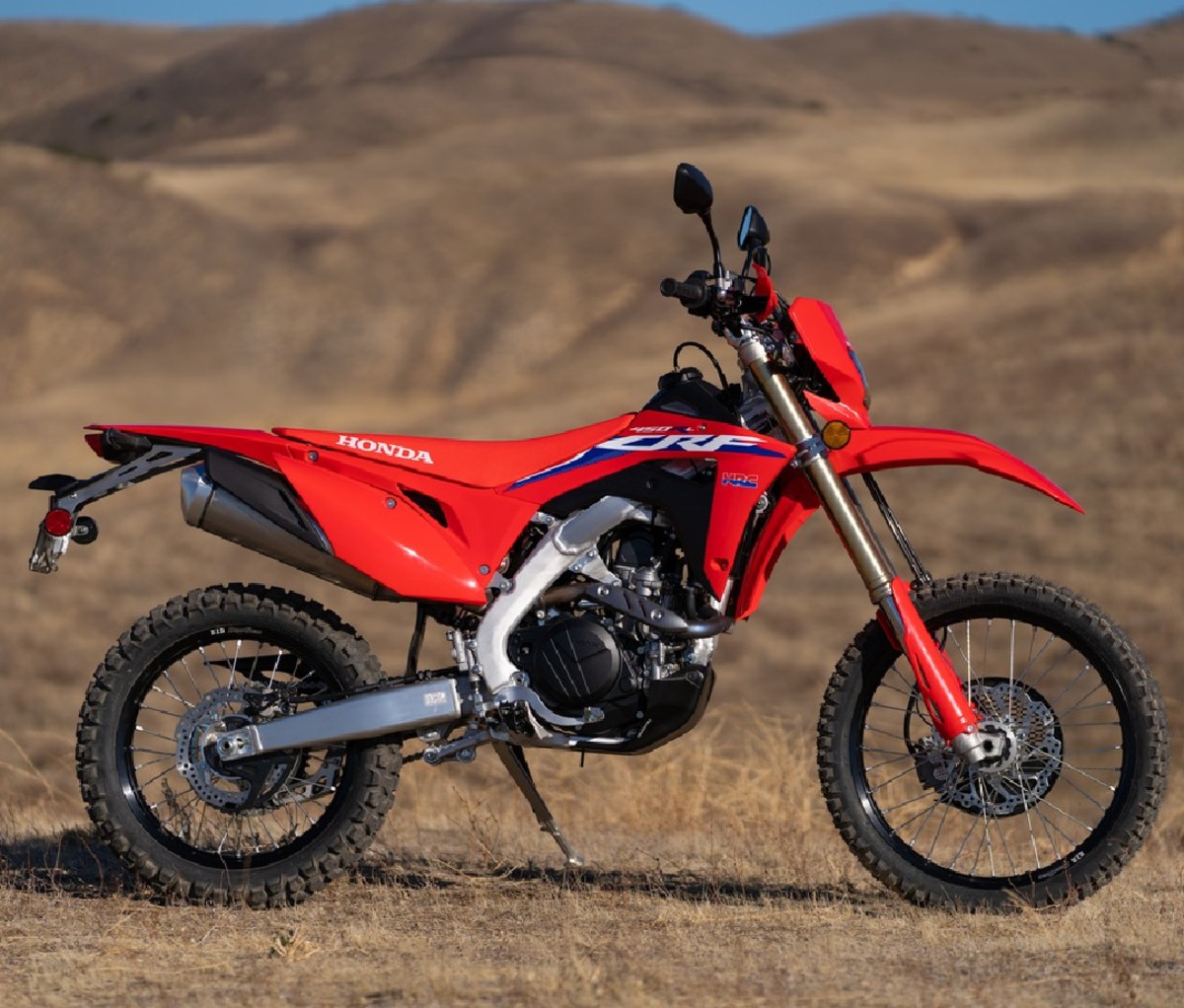 Side profile of red dirt bike against desert landscape