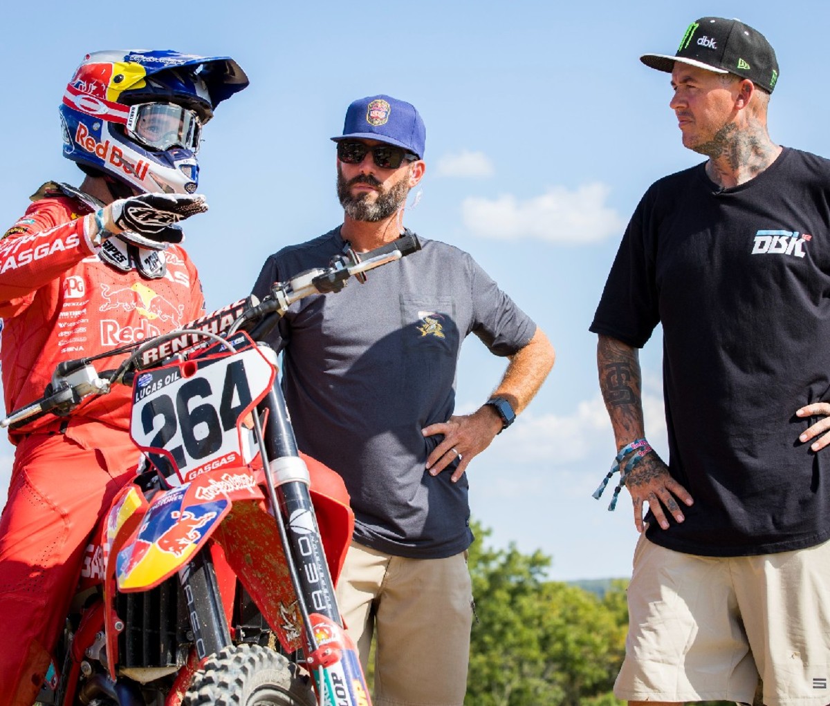 Two men talking to motocross rider