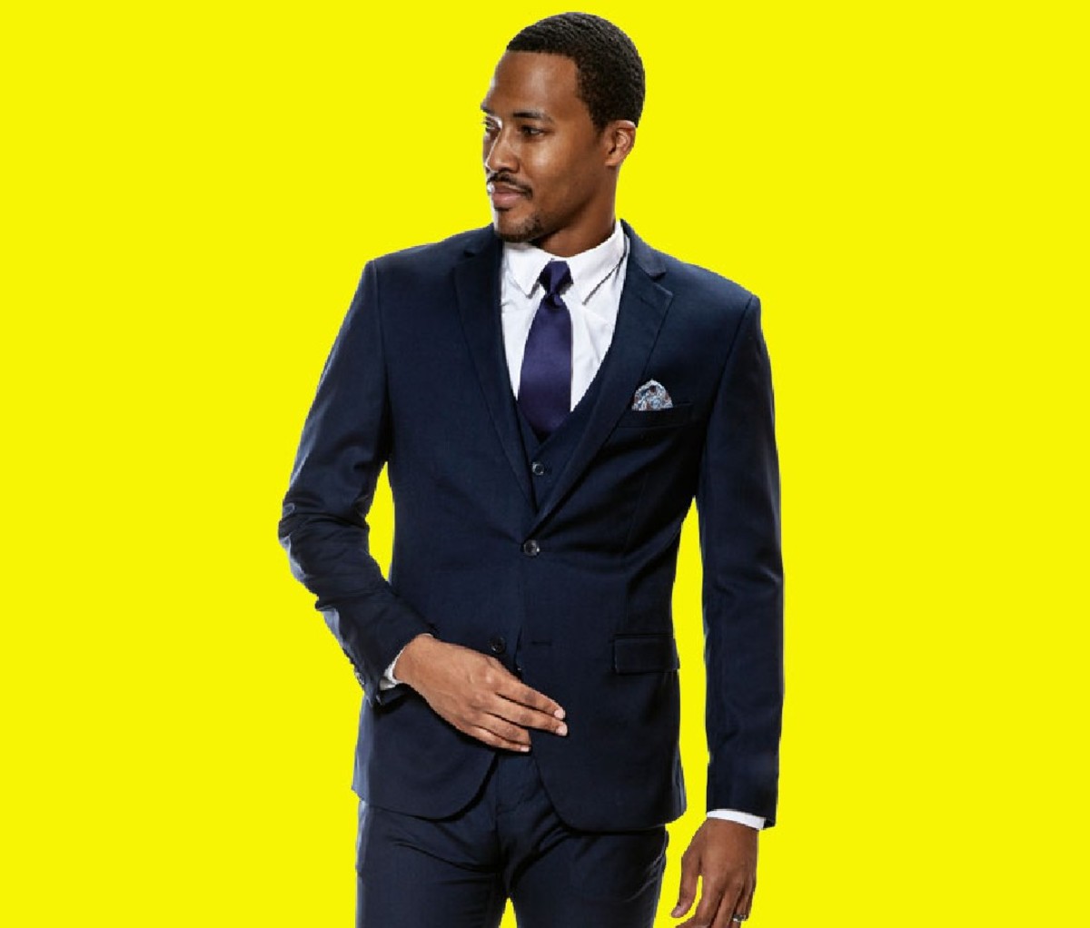 Black man wearing a tuxedo on bright yellow background