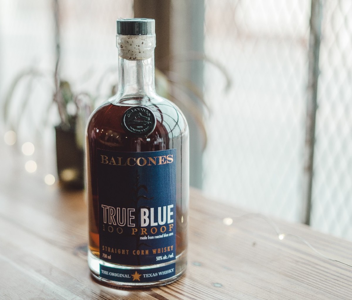 Clear bottle of Balcones True Blue 100 on wooden surface