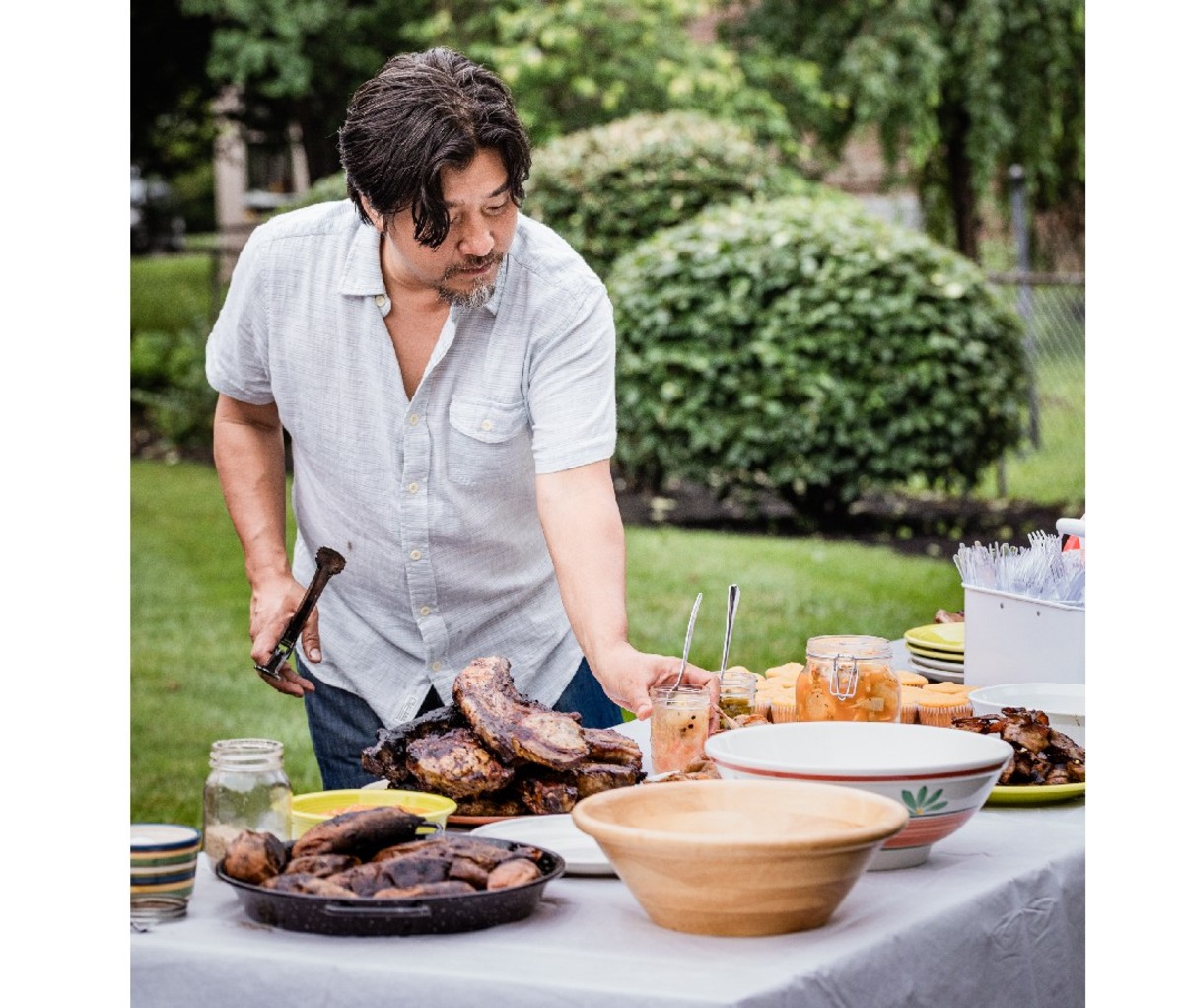 Chef Edward Lee prepeare food on a table outside