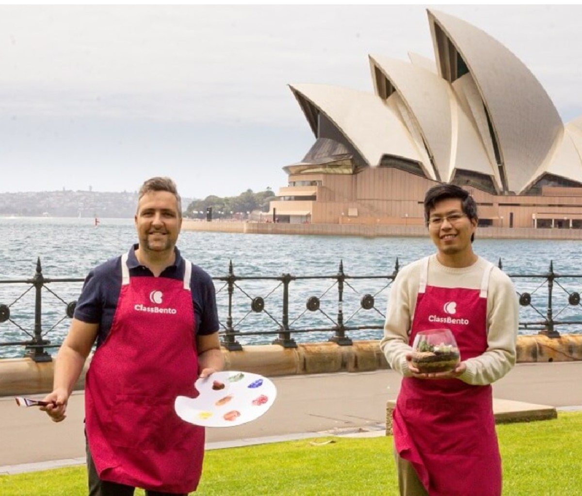 Two ClassBento instructors in red aprons stand outside of the Sydney Opera House