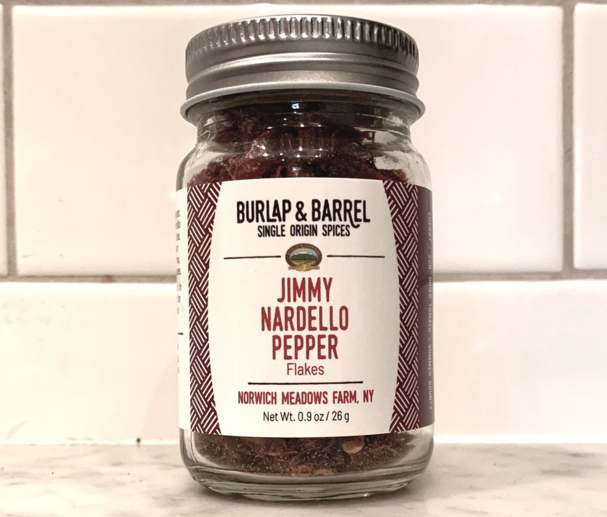 Jar of Burlap & Barrel Jimmy Nardello Pepper Flakes on a white counter