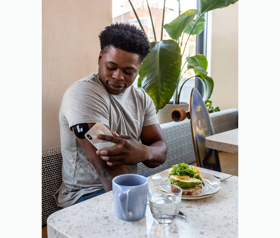 Man checking glucose levels on arm monitor
