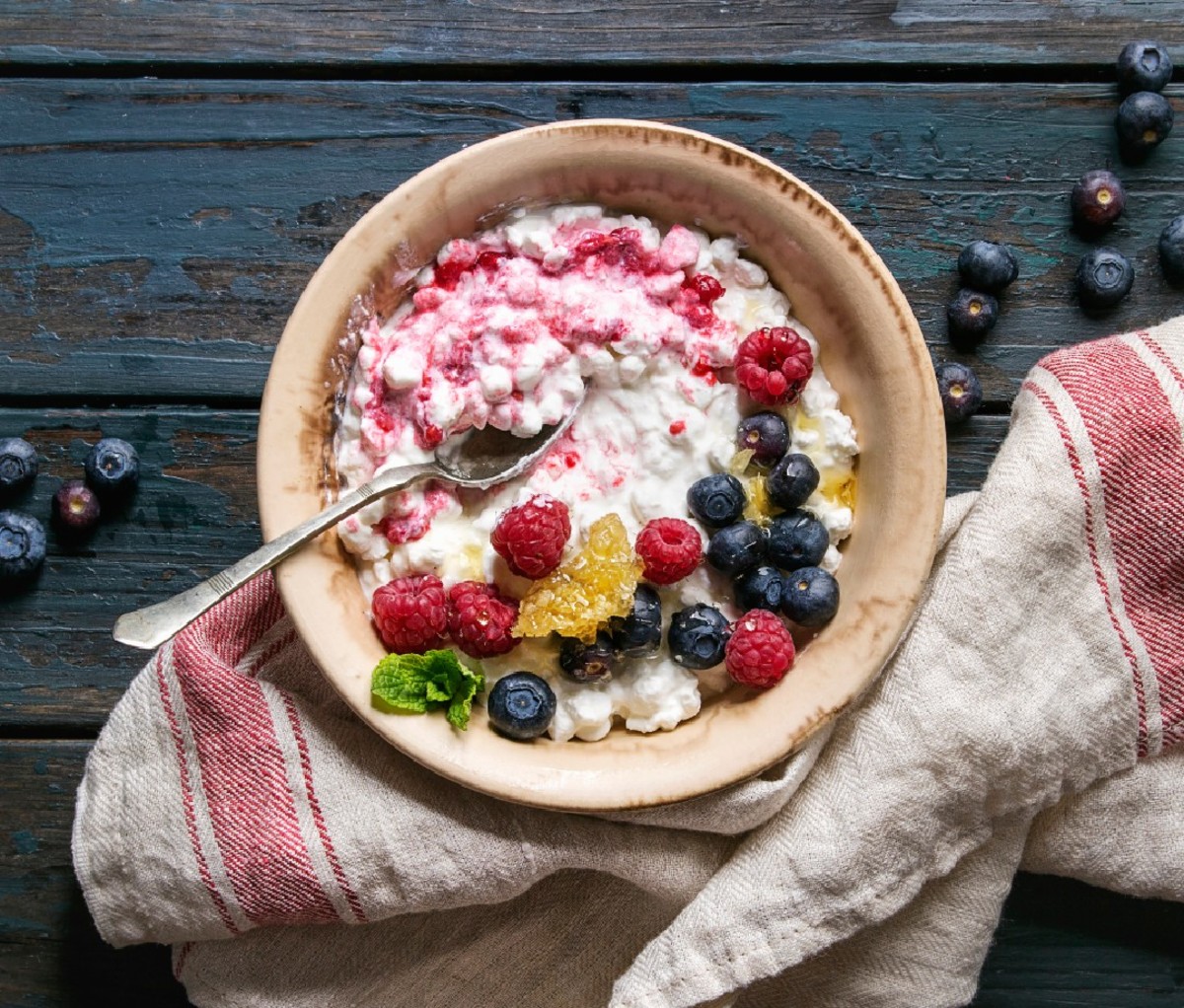 Cottage cheese in bowl with blueberries and raspberries