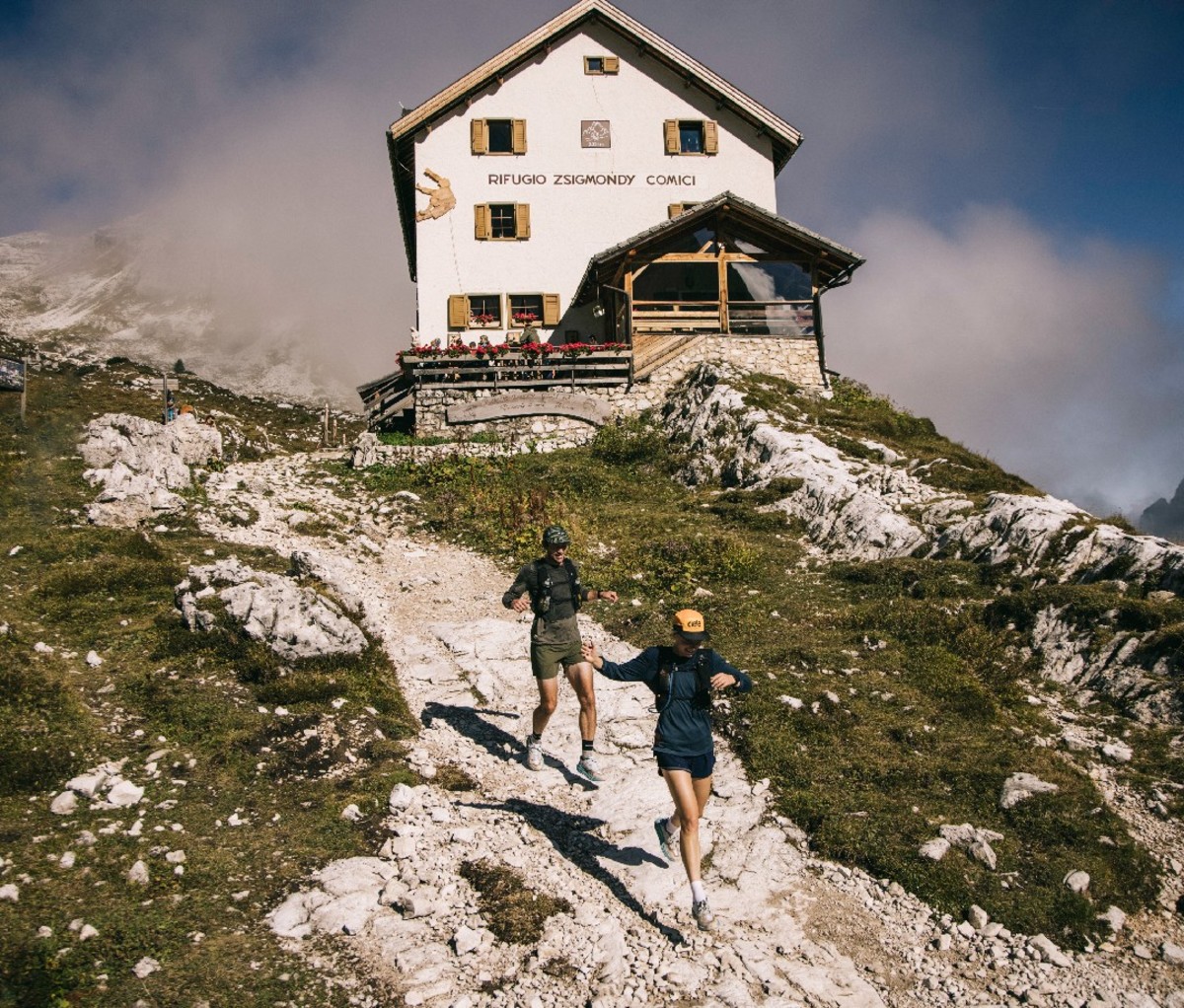 Trail runners coming down from lodge in mountains
