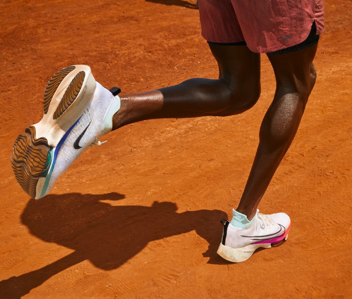 Nahaufnahme der Waden eines schwarzen Läufers, der in Nike-Schuhen läuft