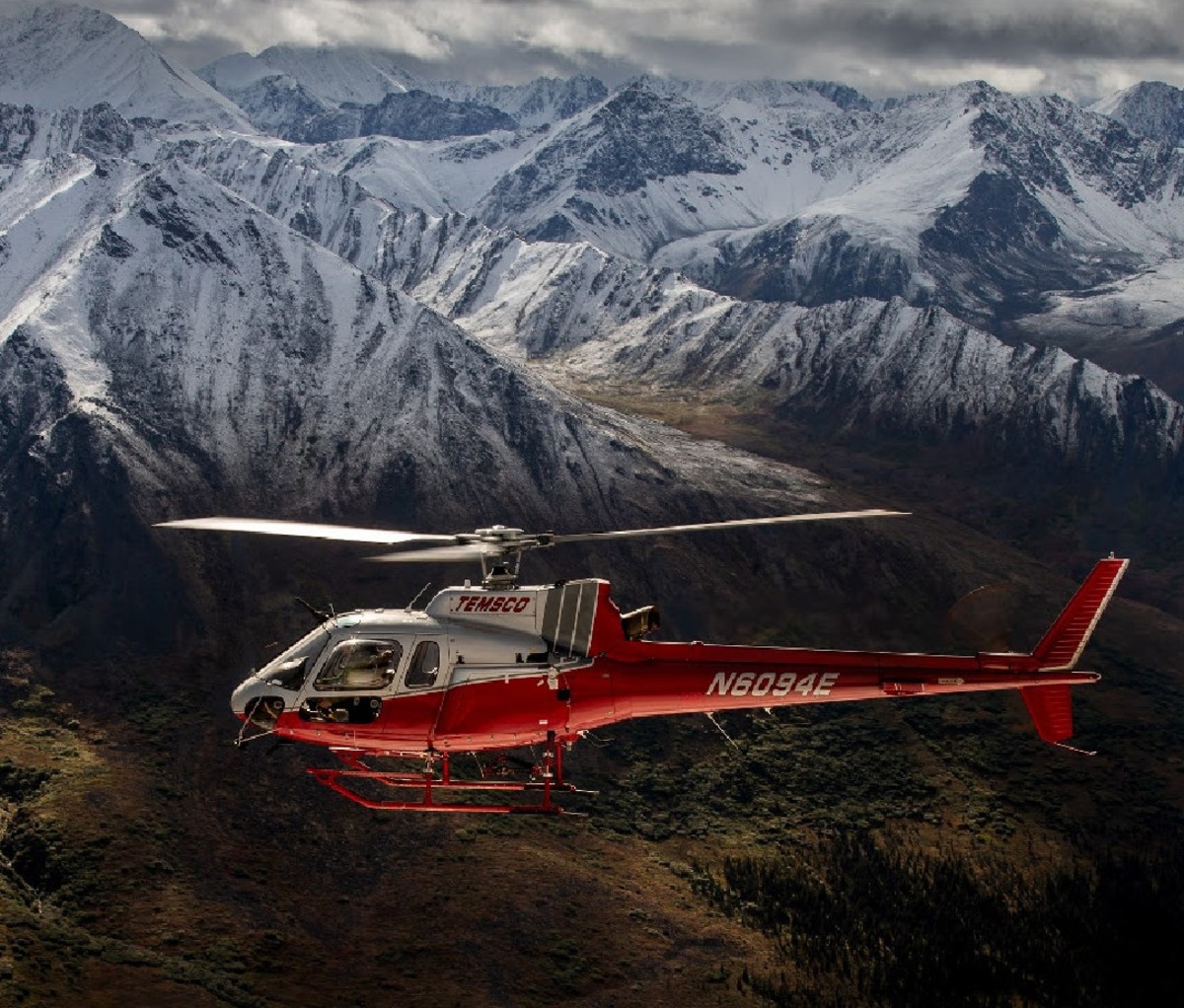 Red helicopter flying past mountainscape in Denali National Park