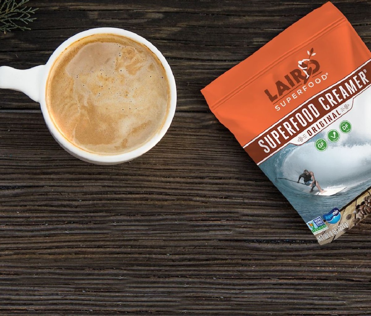Packet of Laird Superfood Coconut Creamer next to a cup of coffee with the creamer