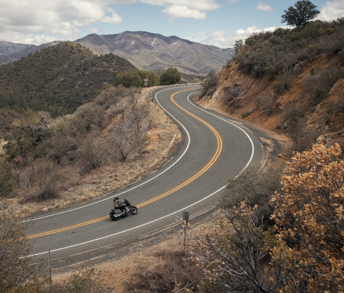 Long shot of a rider on an Indian Chief motorcycle riding along a curved mountain road