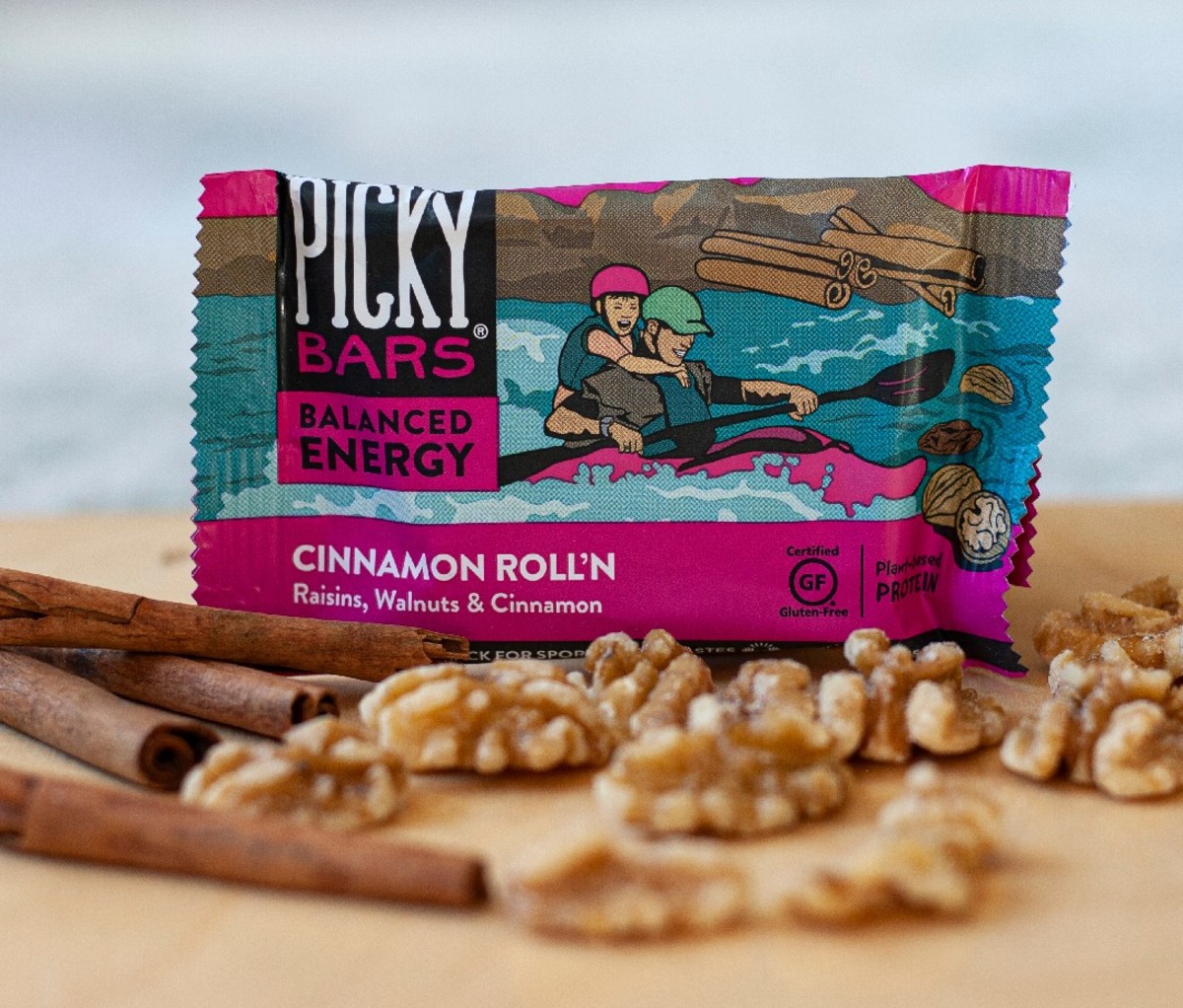 Laird Picky Bar in a package on counter behind cinnamon sticks and walnuts