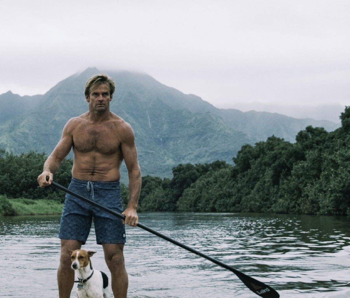 Laird Hamlton on a paddleboard in Hawaii with his dog