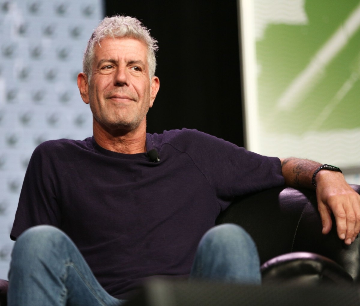 Anthony Bourdain sitting in a chair onstage