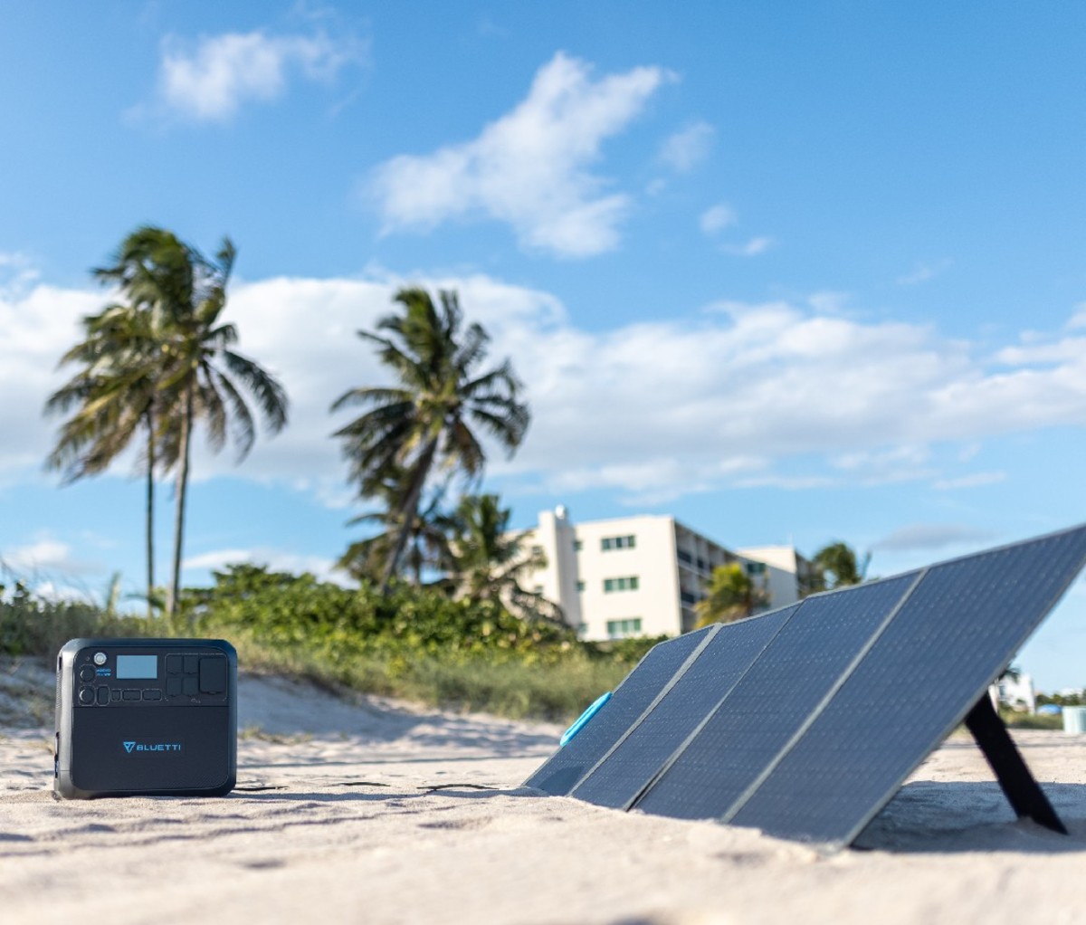 Open solar panels set up on the beach next to Bluetti portable power station