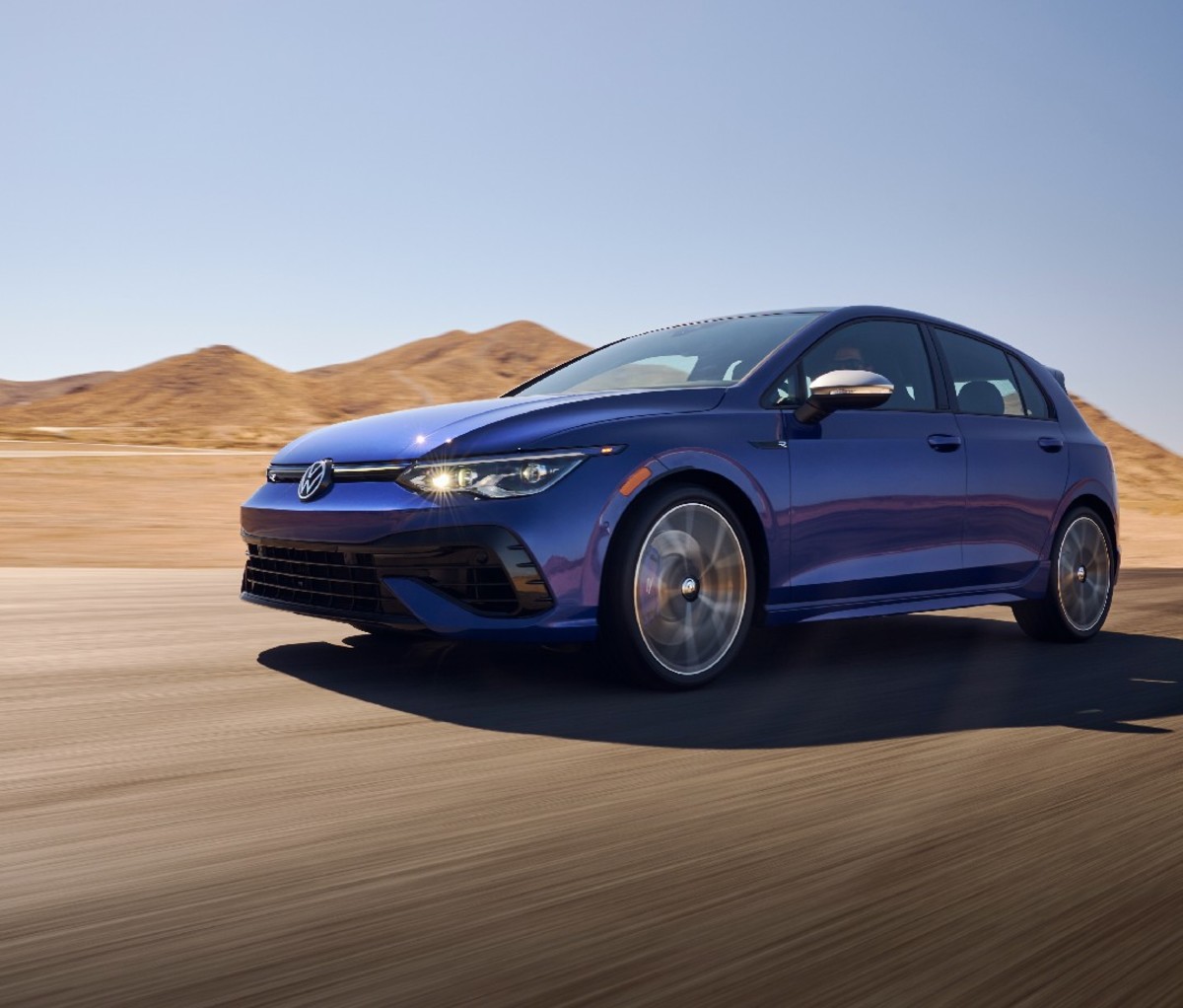 Blue four-door sedan with desert landscape in background