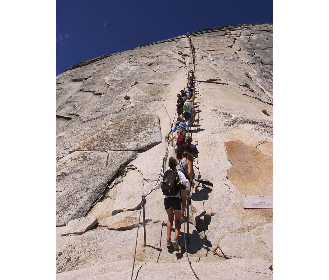 People climbing steep cable ladder