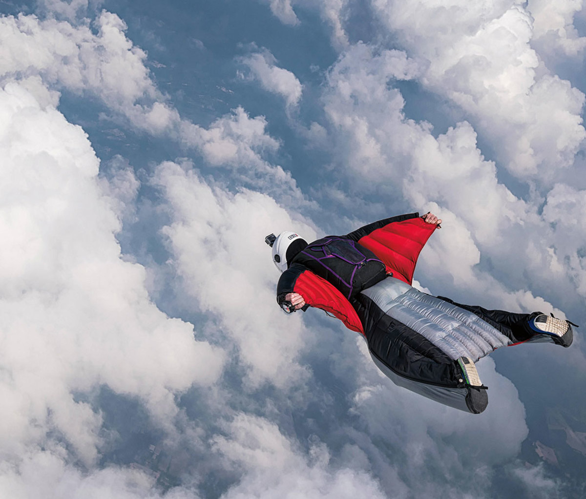 Person in wingsuit gliding in sky