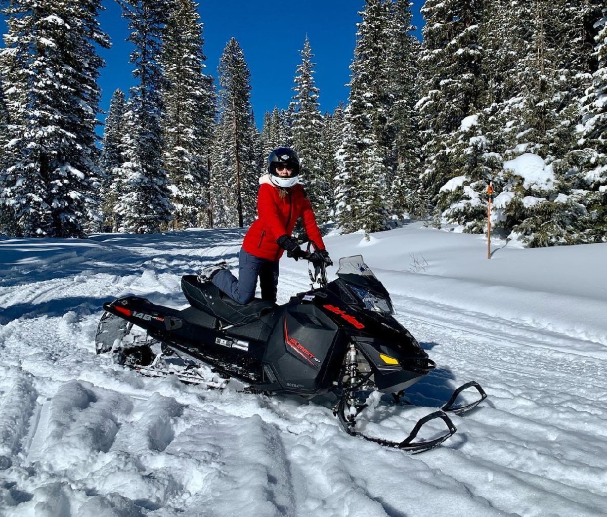 Woman on a snowmobile on snowy tracks in Grand Mesa National Forest, Colorado