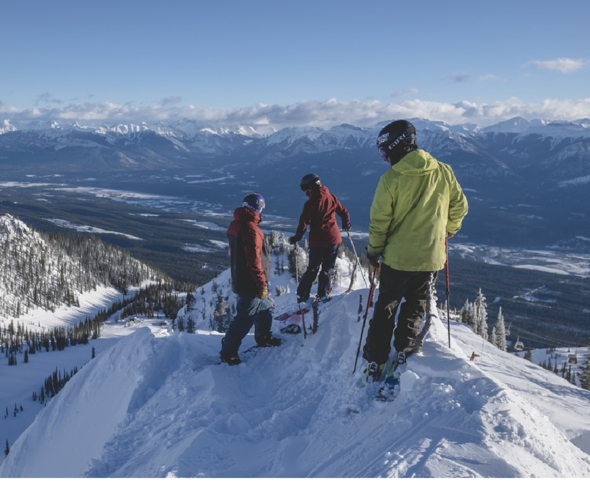 Skiers perched on a snowy peak at Kicking Horse Mountain Resort, British Columbia