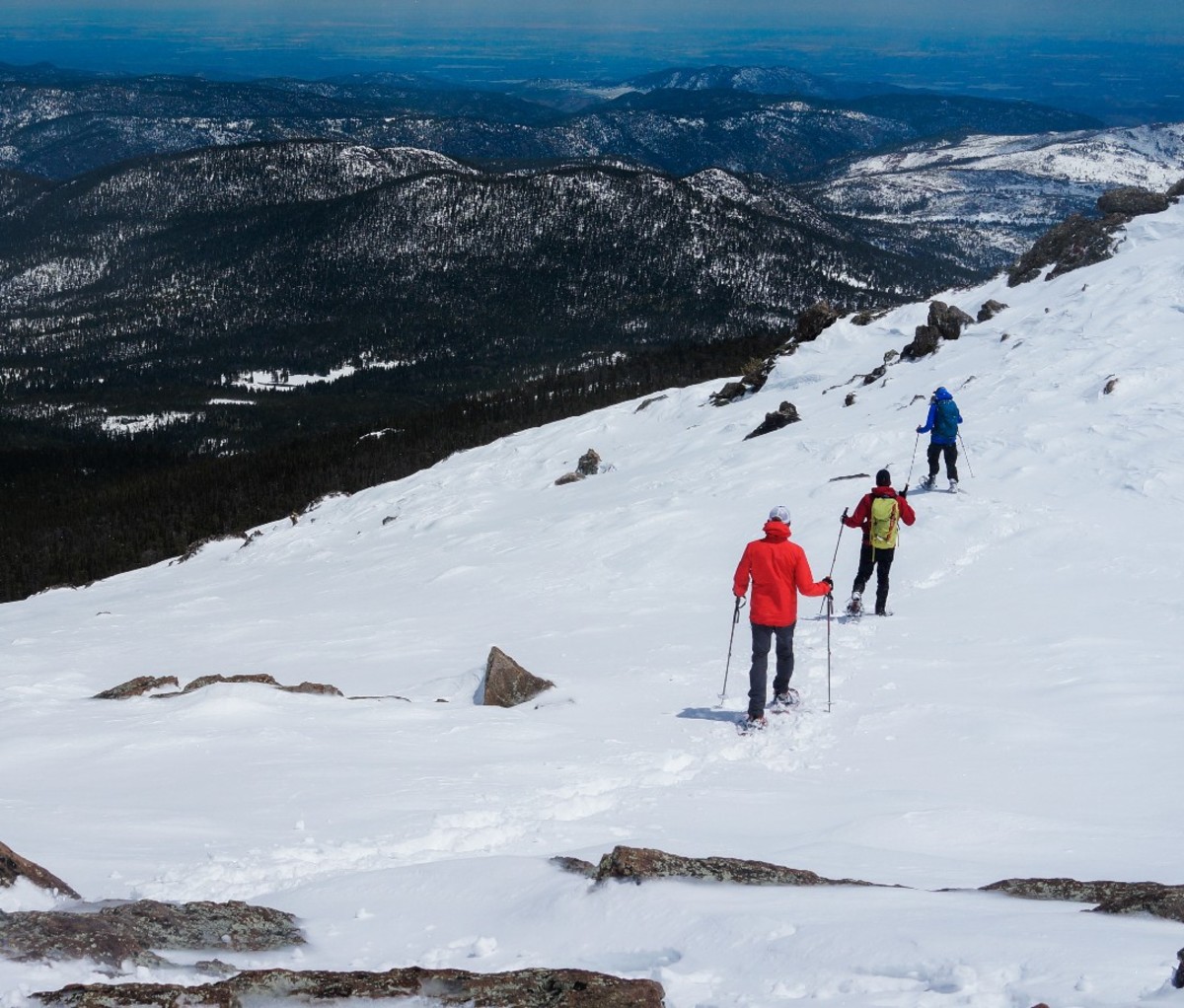 Group of people are hiking on the top of the mountain with snow in Colorado.
