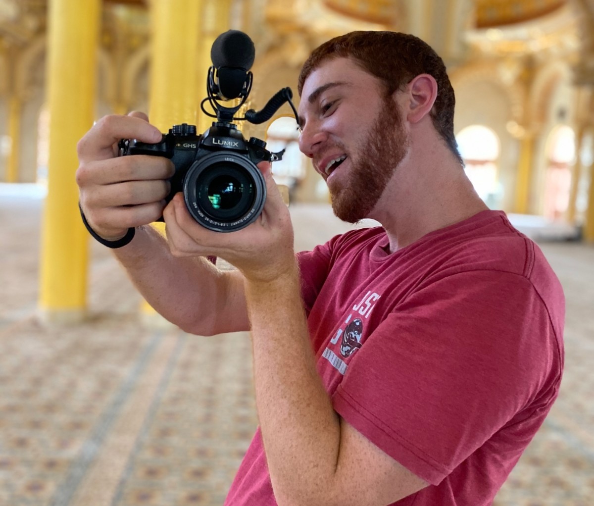 Drew Binsky in a red shirt holding a camera