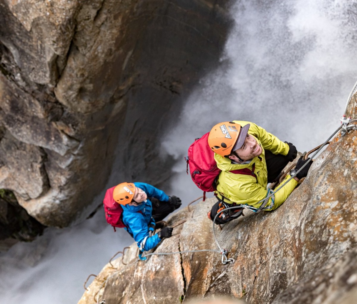 Two climbers ascending a Via Ferrata cliff in the Cariboo Mountains