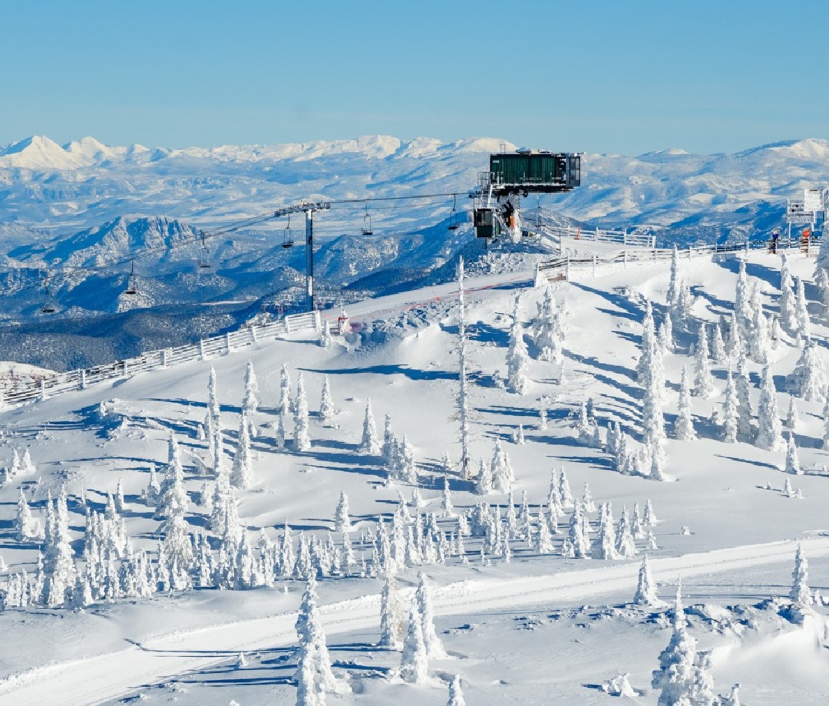 Aerial image of snow covered upper mountain and top of chair lift at Brian Head Resort