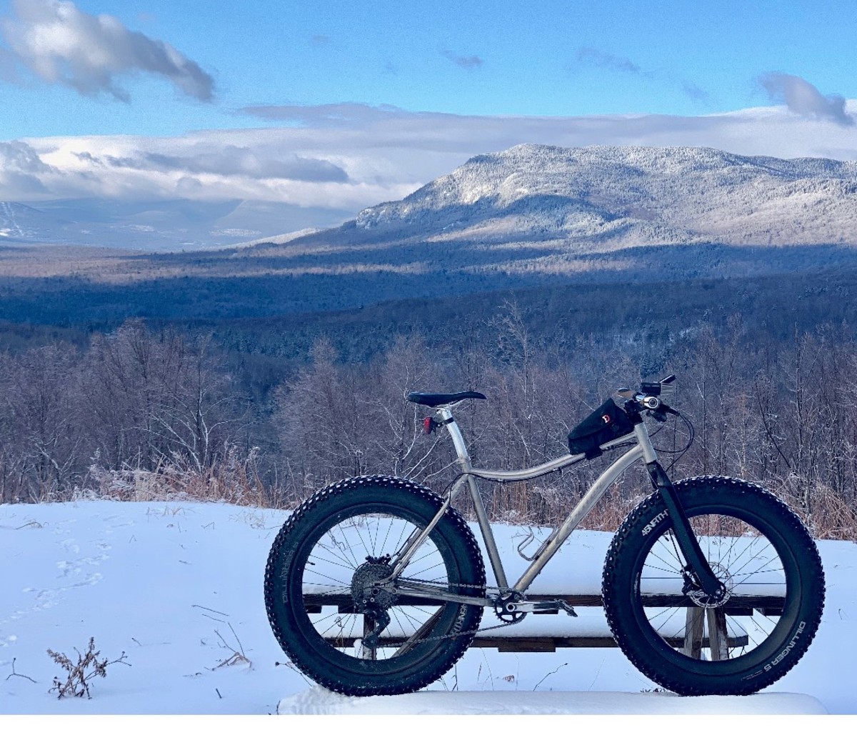 A fat bike stands in the snow with a mountain in the background in Maine's Carrabassett Valley.