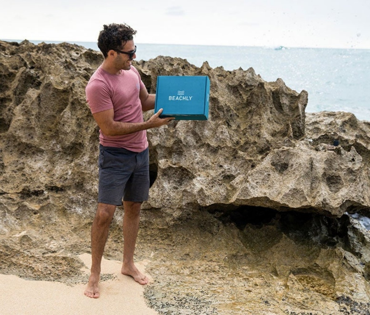 Man standing on beach with a Beachly box