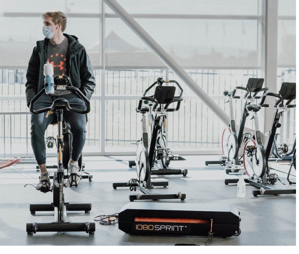 Team USA speed skater Conor McDermott-Mostowy sitting on stationary bike at gym