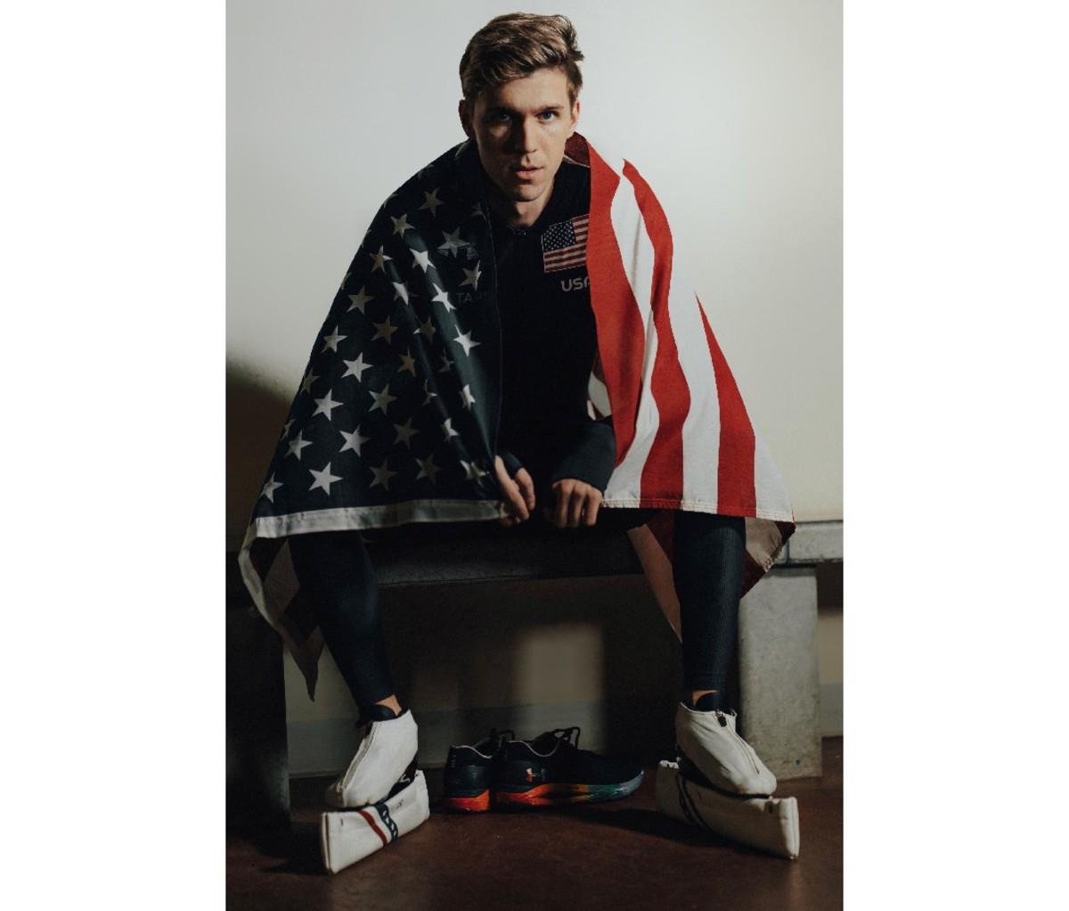 Team USA speed skater Conor McDermott-Mostowy draped in a US flag