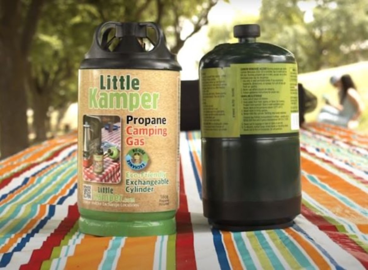 Two Little Kamper fuel cannisters on a picnic table at a campground