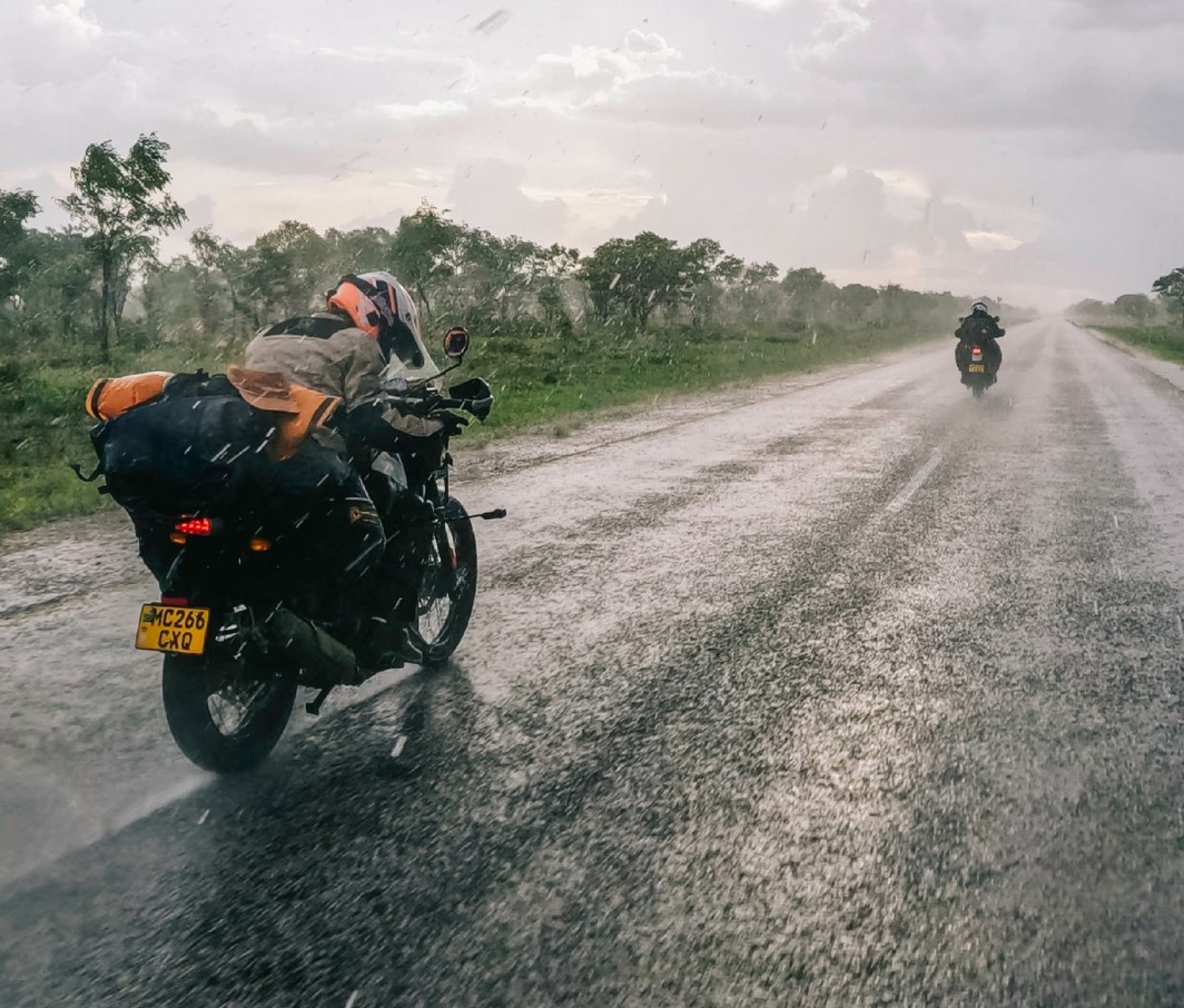 Motorcyclists ride along an asphalt road in the rain during the Kili-Cape Town ride