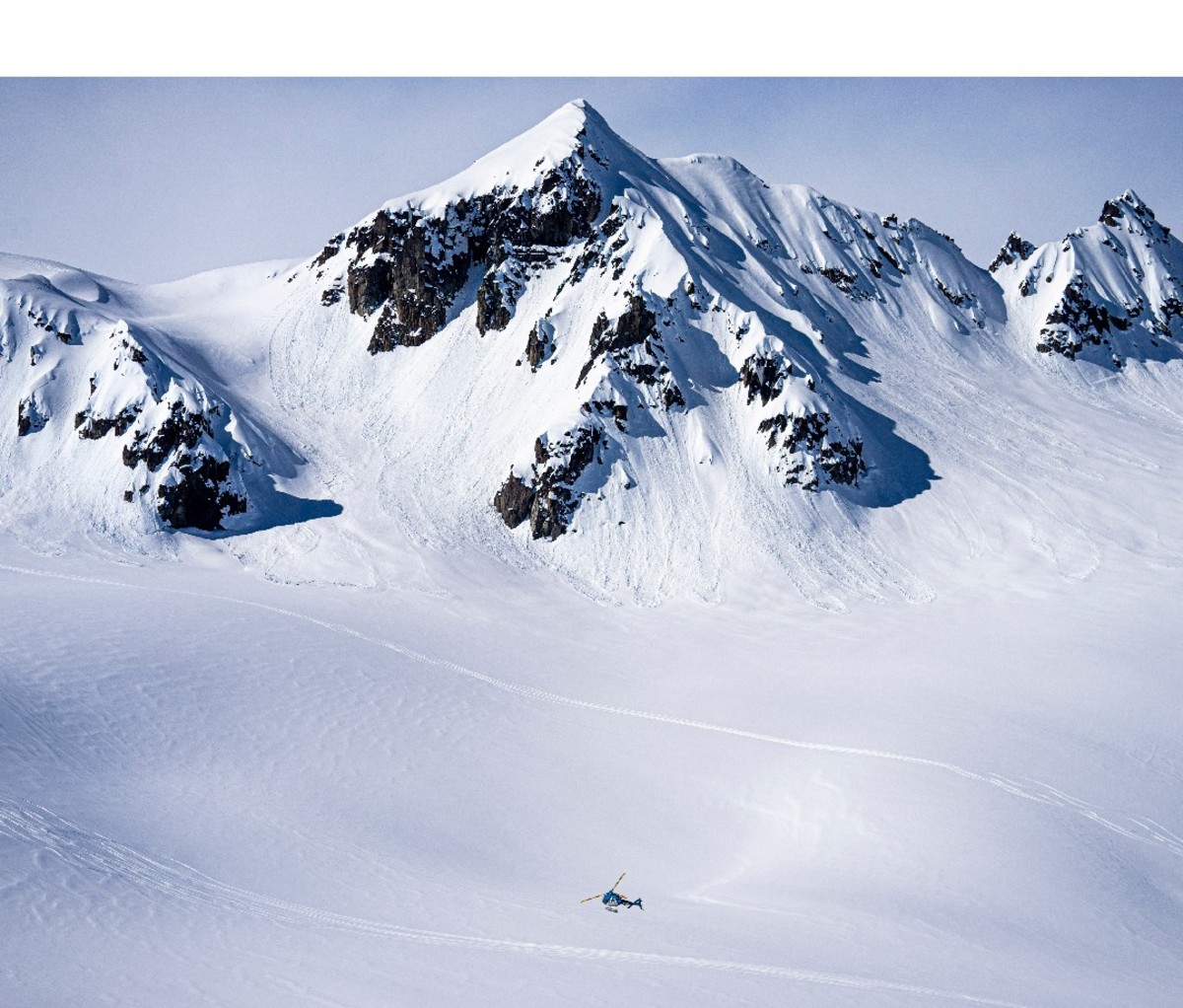 Distant image of helicopter flying past giant mountain