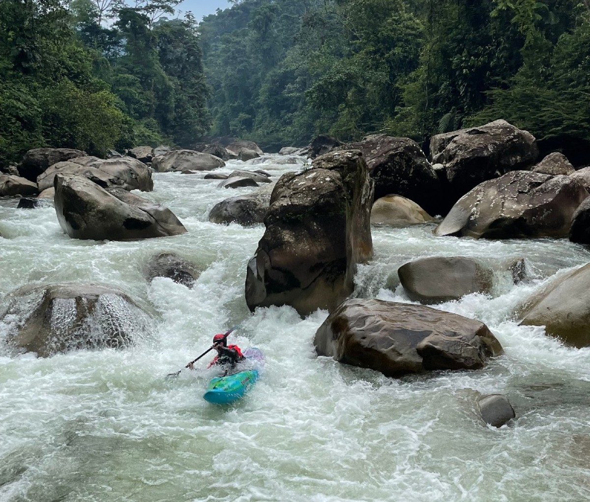Kayaker slaloms through a rocky patch of whitewater in Ecuador