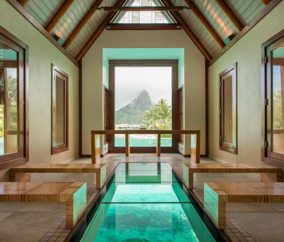 Tropical lodging with blue water running through building