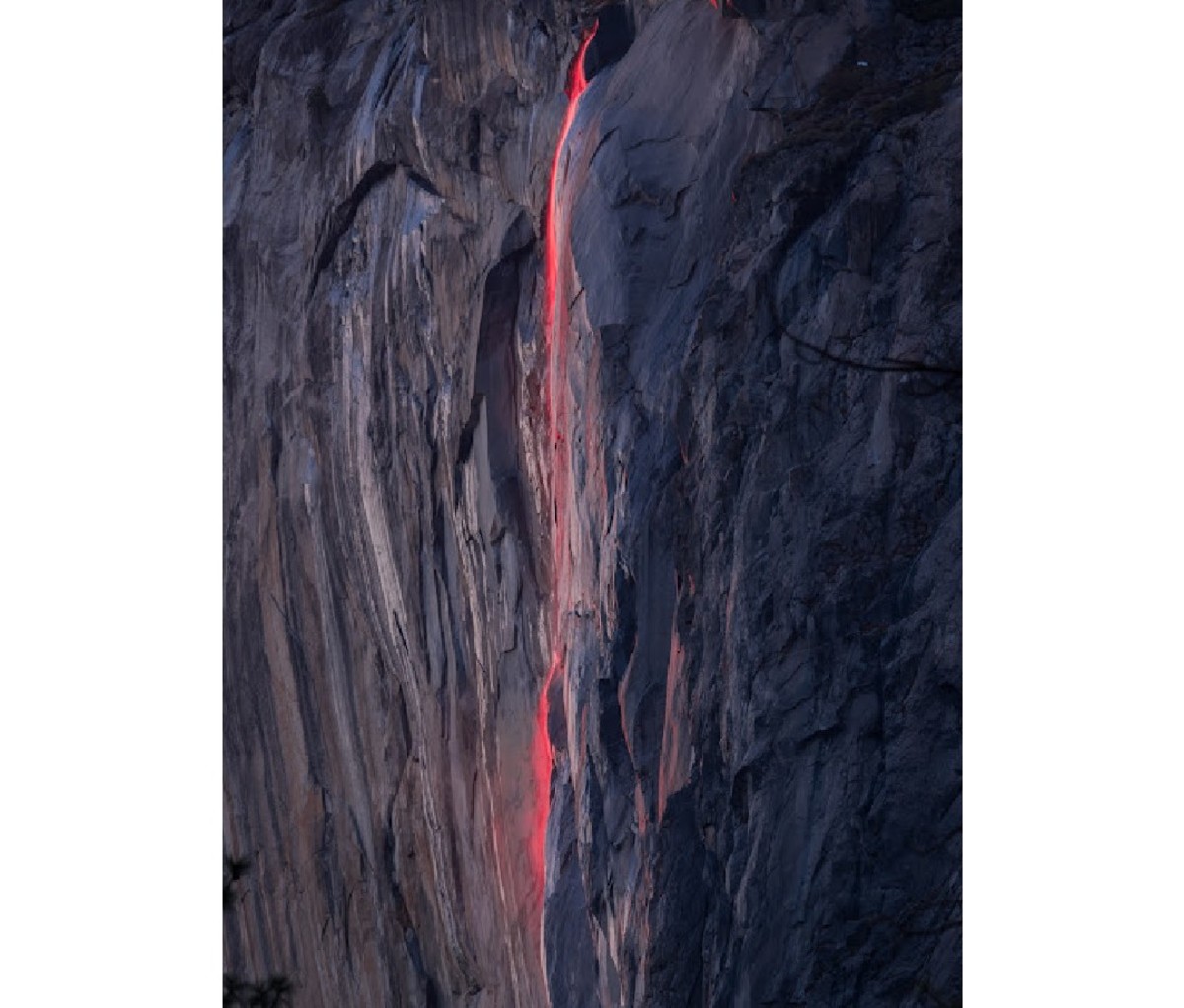Horsetail Falls glowing red down the sheer dark cliff face of El Capitan in Yosemite National Park