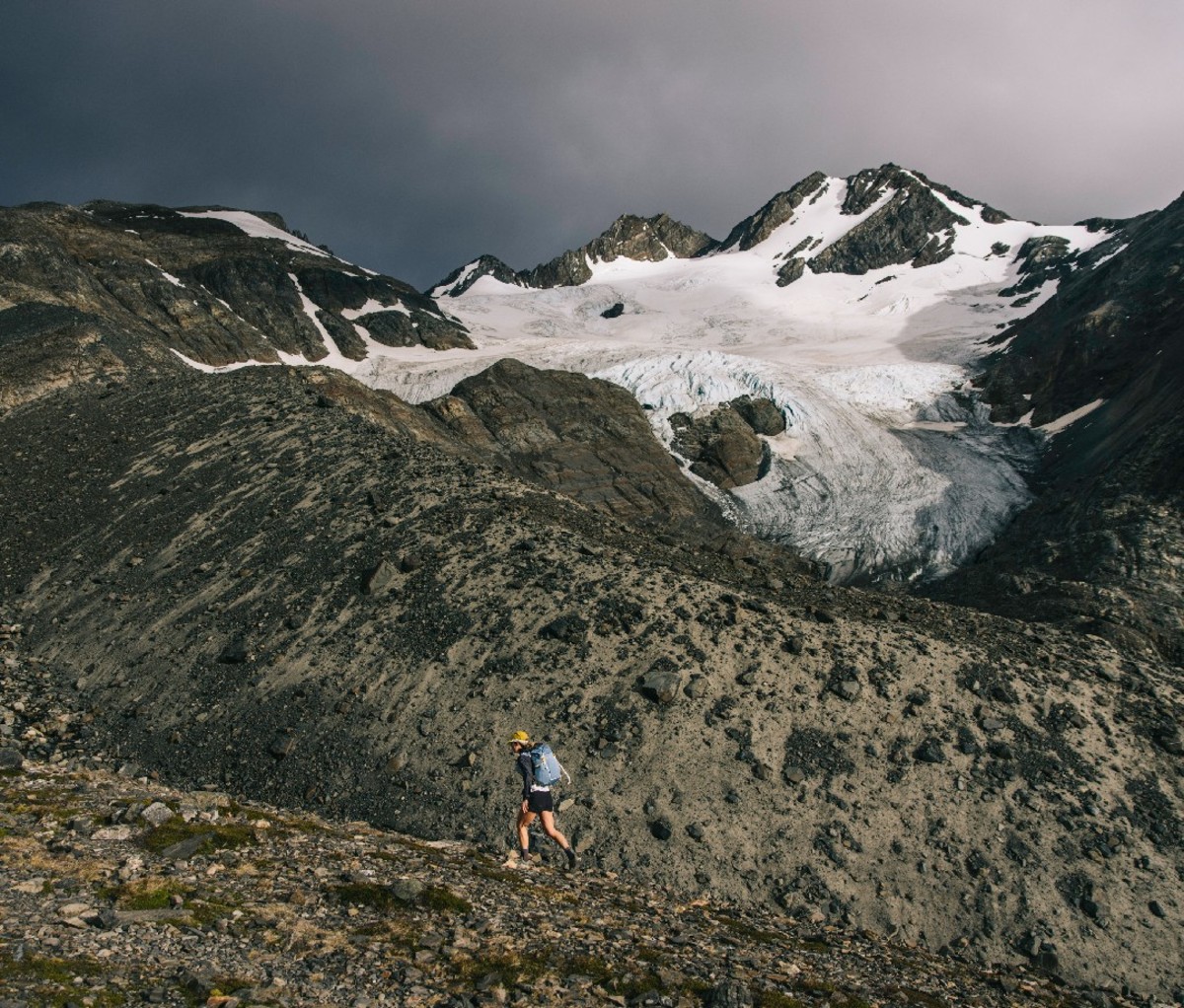 Hiker treks along a glaciated saddle in the mountains of Torres del Paine National Park