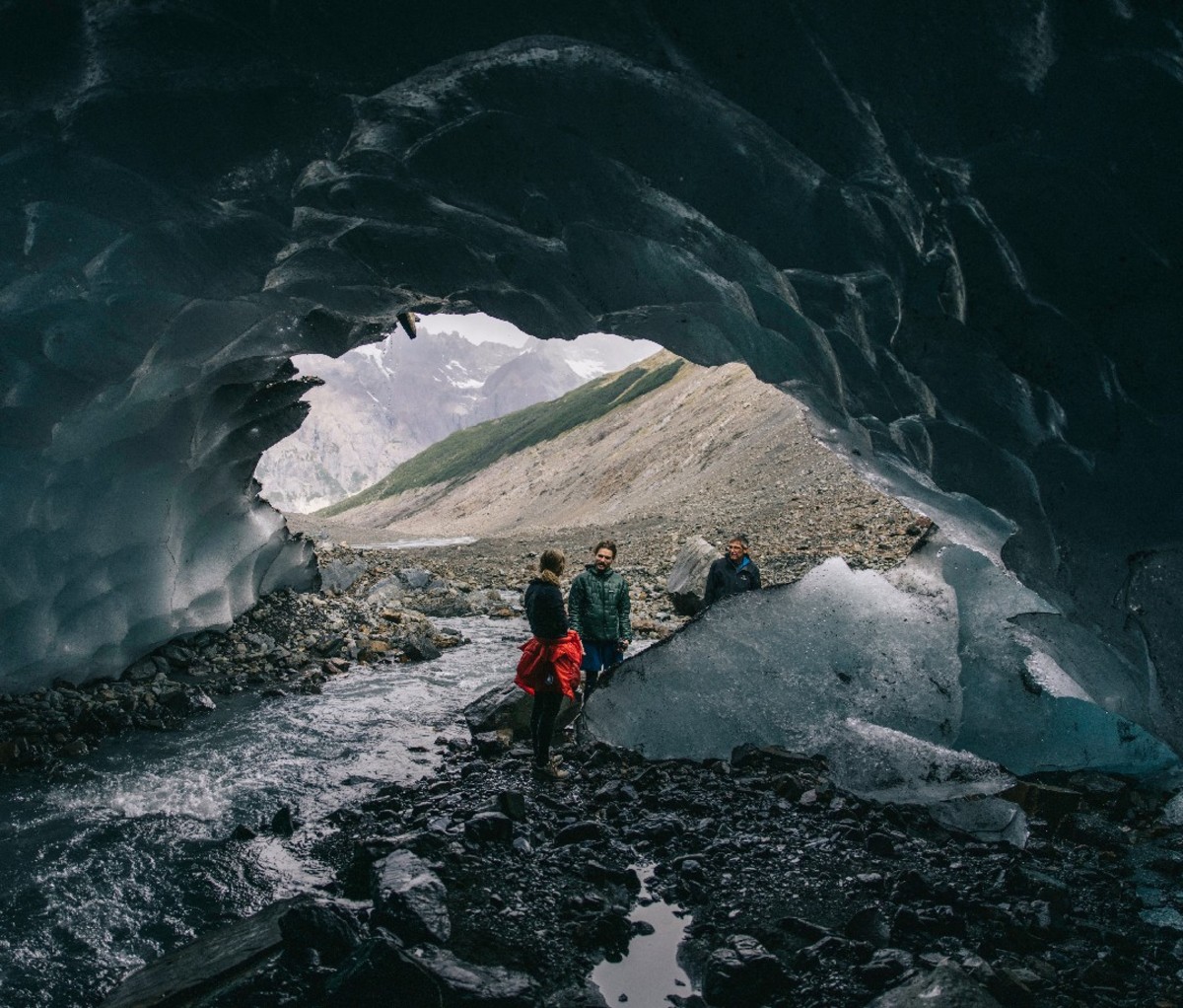 Hikers in Torres del Paine National Park explore the mouth of an ice cave