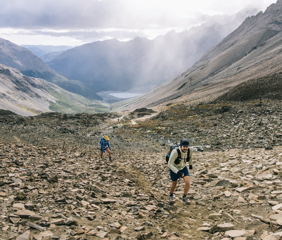 Two hikers trek through a slope of rocks and scree along the O Circuit trail in Torres del Paine National Park