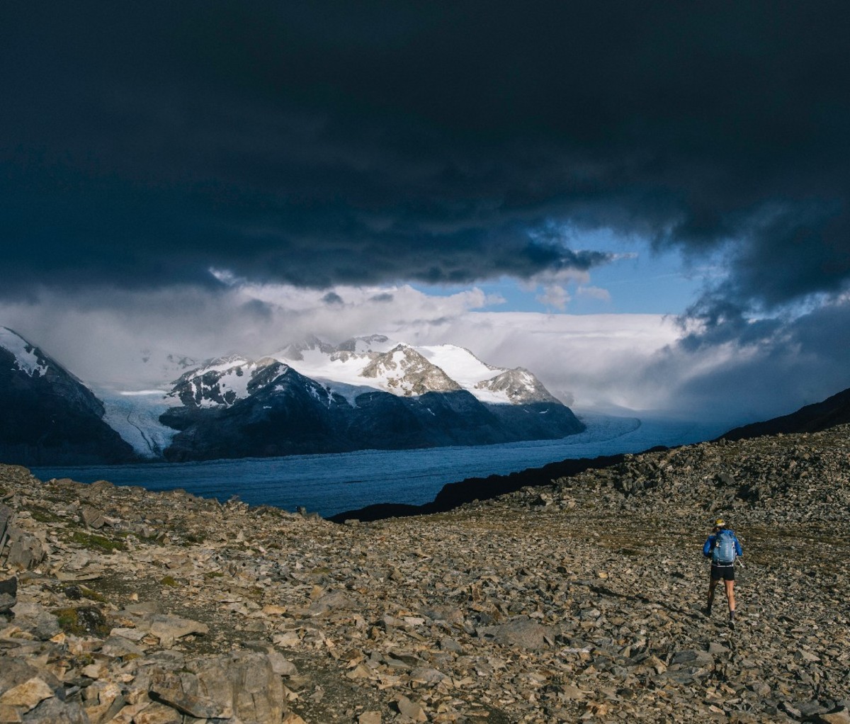 Dark clouds roll over a rocky trail with a mountain backdrop in Torres del Paine National Park